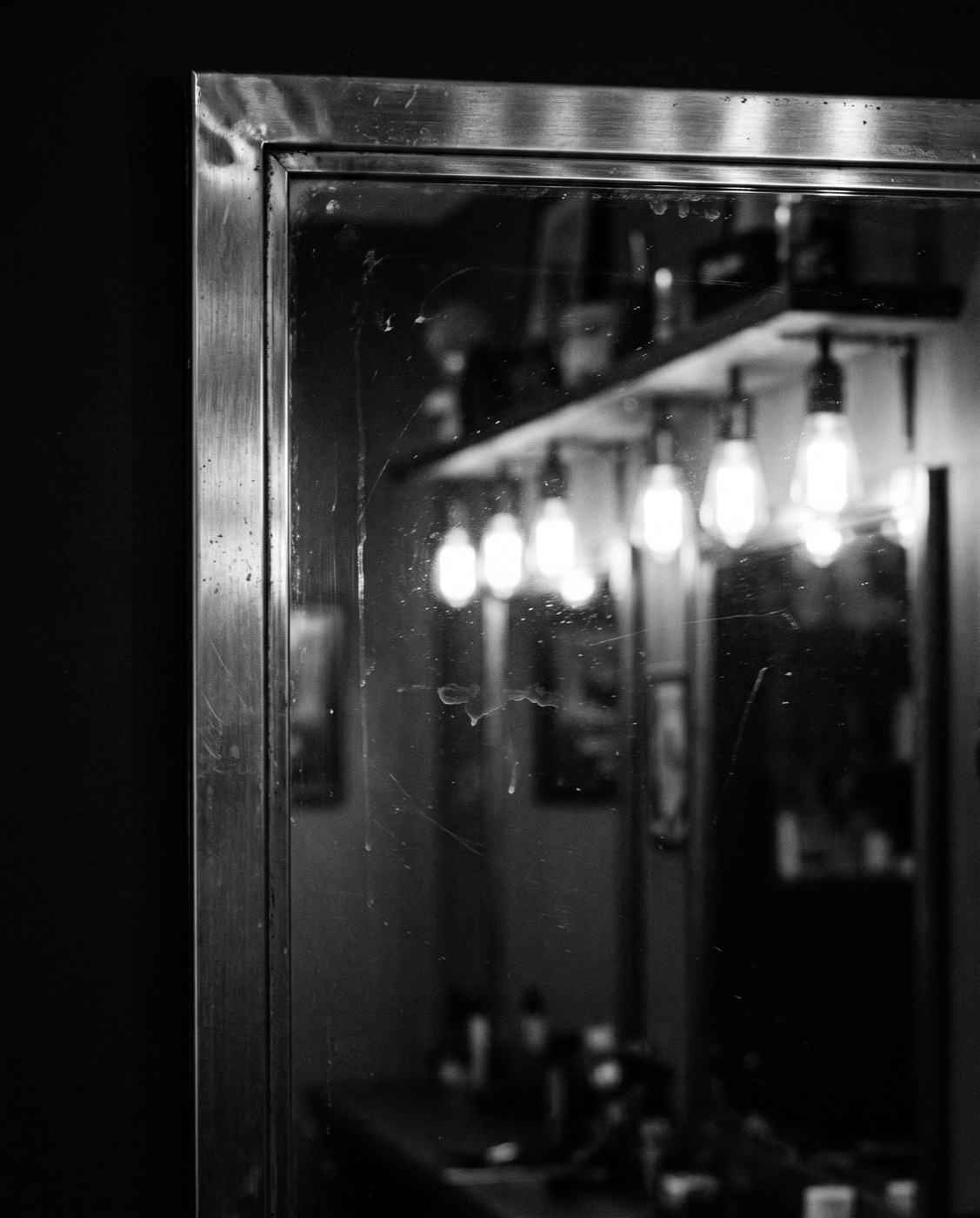 Spiegel mit warmem Licht im Amir Barbershop in Köln-Innenstadt